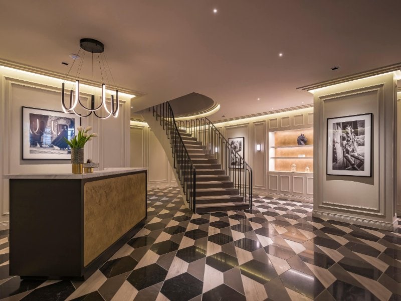 Elegant lobby with a checkered marble floor and curved staircase at The Amsterdam in Condesa, Mexico City