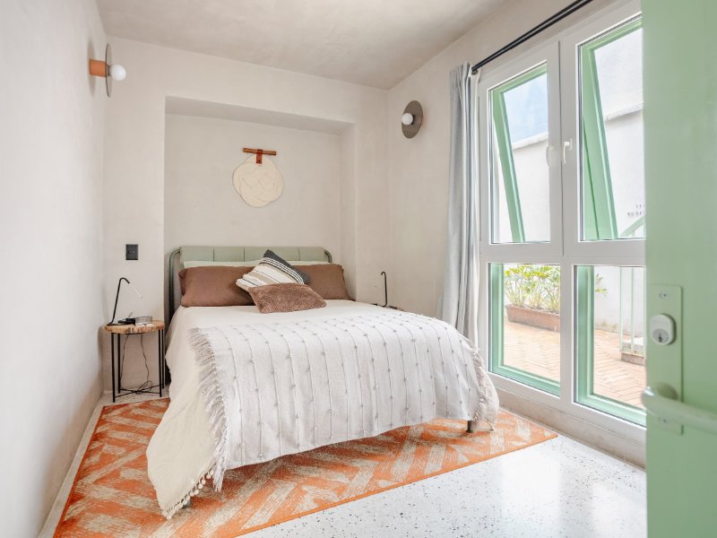 Bright bedroom with green doors at the quiet 1-bedroom Airbnb across from the Coyoacán market
