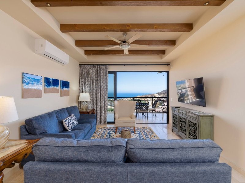 Living room opening onto the terrace at Reel Paradise, an ocean-view condo at Copala in Quivira, Cabo San Lucas
