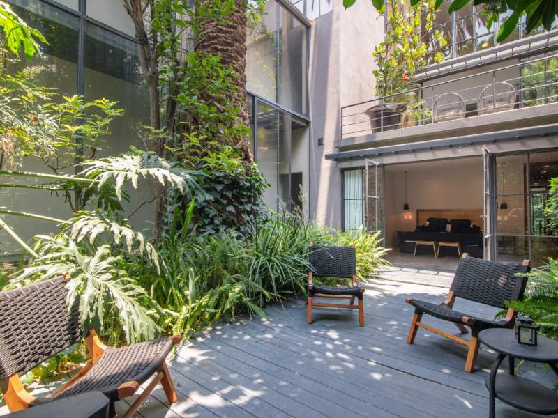 Plant-filled central patio with lounge chairs at the Serviced 4-Bedroom Designer Mansion in Condesa, Mexico City