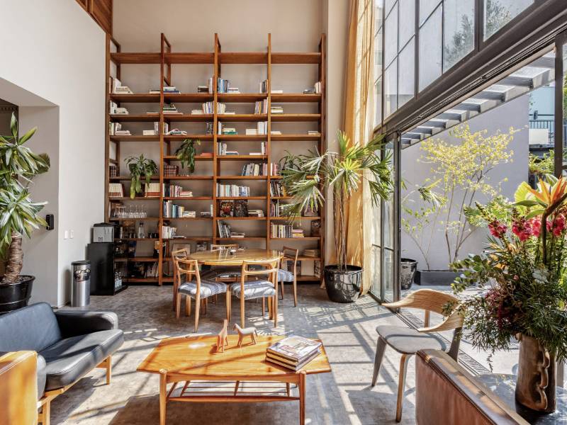 Double-height living room with floor-to-ceiling bookshelves at the Serviced 4-Bedroom Designer Mansion, a luxury Airbnb in Mexico City's Condesa