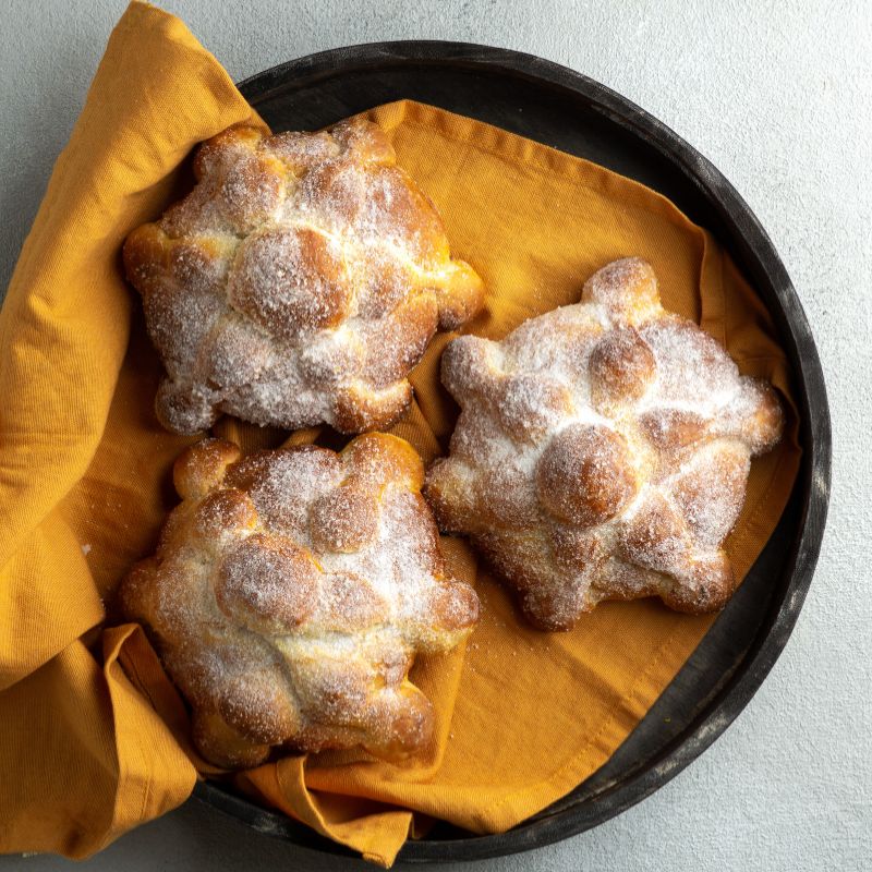 plate with 3 panes de muerto (day of the dead bread)