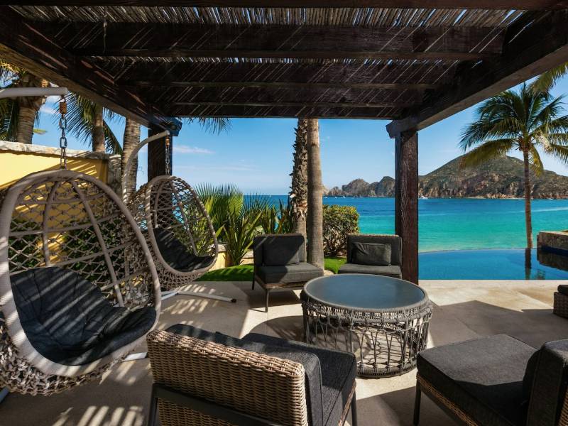 Shaded terrace with hanging chairs facing Médano Beach at Villa 1, Hacienda Beach Club, Cabo San Lucas