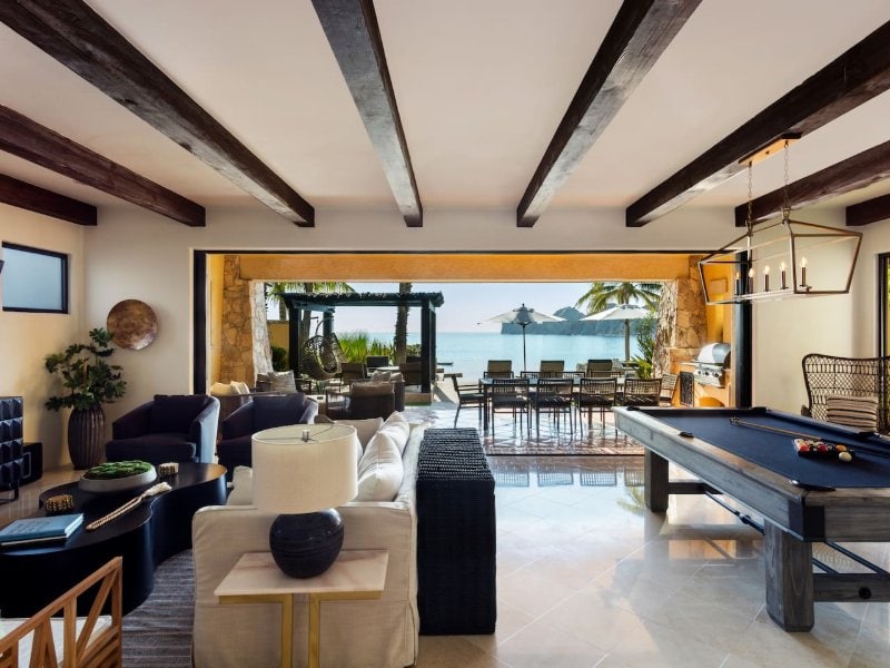 Living room with a pool table opening onto Médano Beach at Villa 1, Hacienda Beach Club, Cabo San Lucas